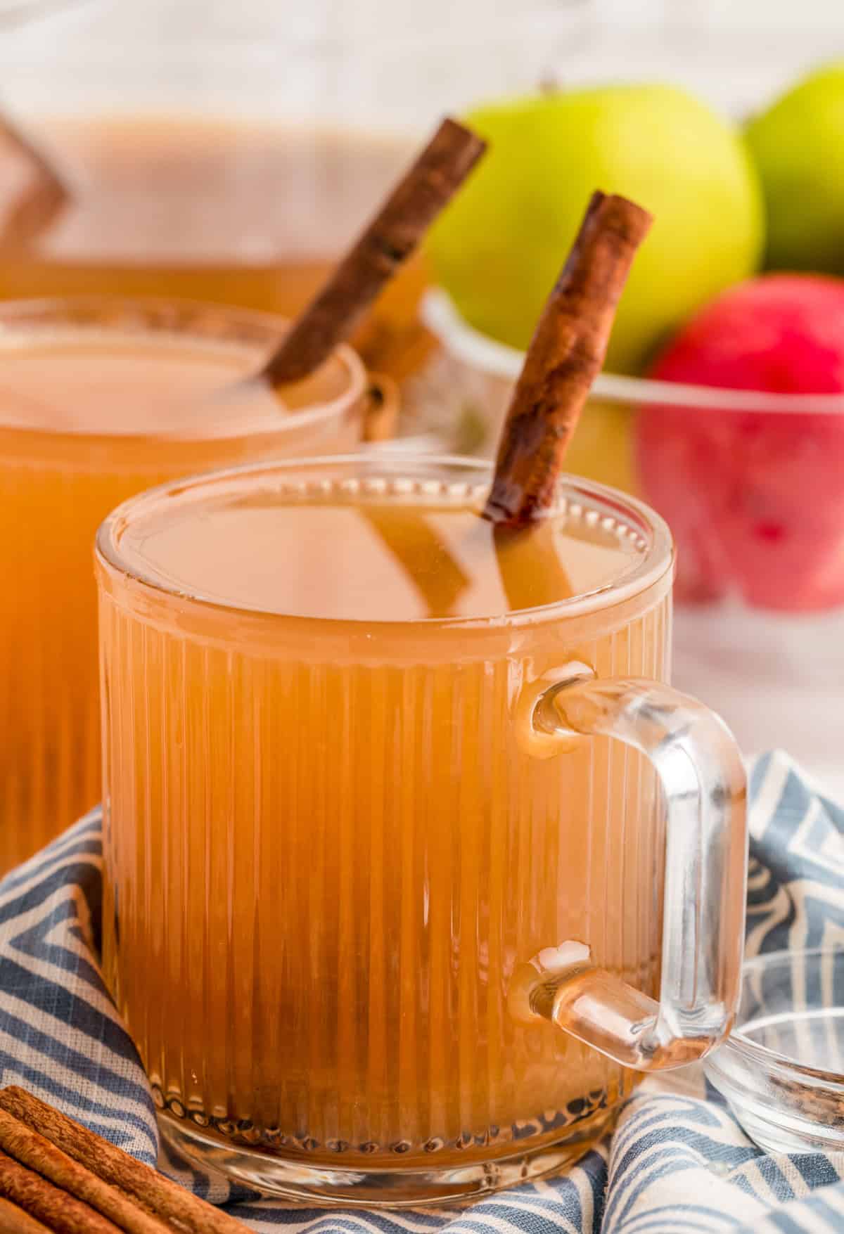 Homemade Apple Cider in ribbed glass with handle served with a cinnamon stick.