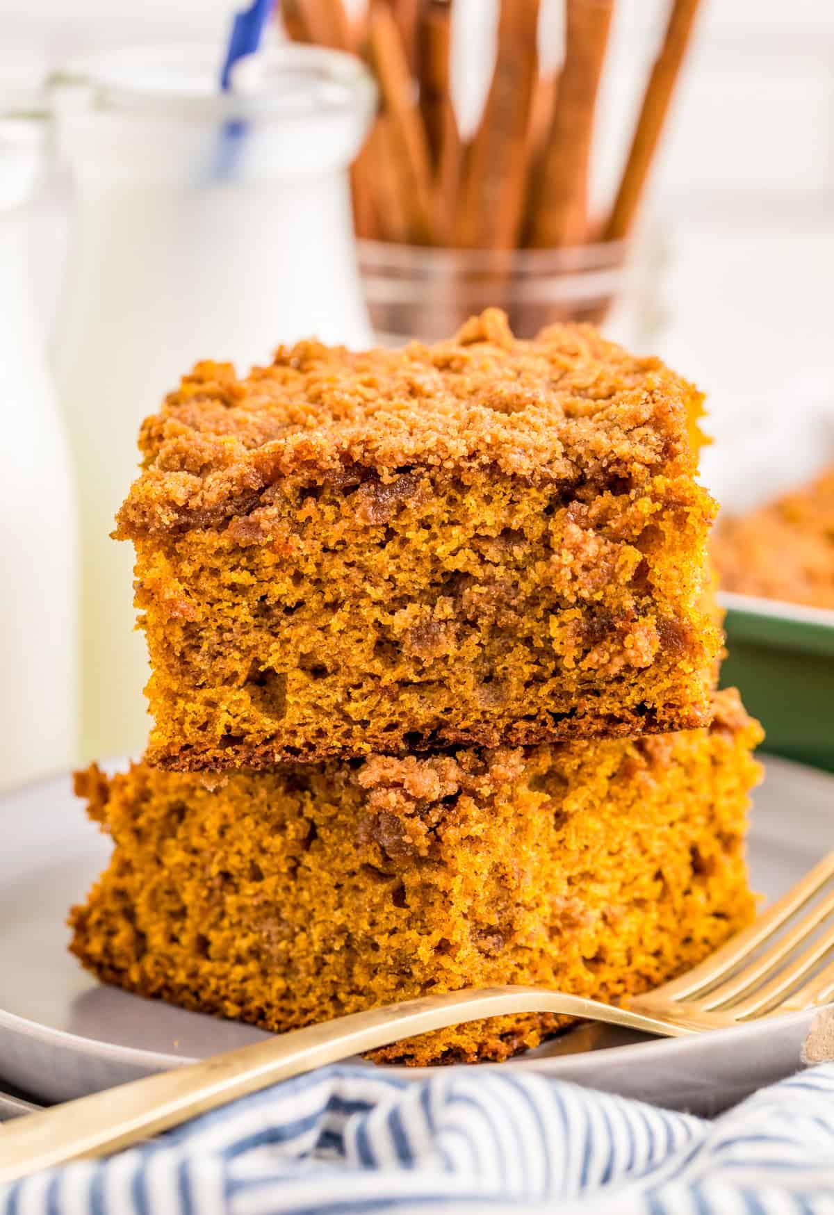 Two slices of Pumpkin Coffee Cake stacked on top of one another on plate with fork.