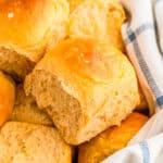 Close up square image of rolls in basket with linen.
