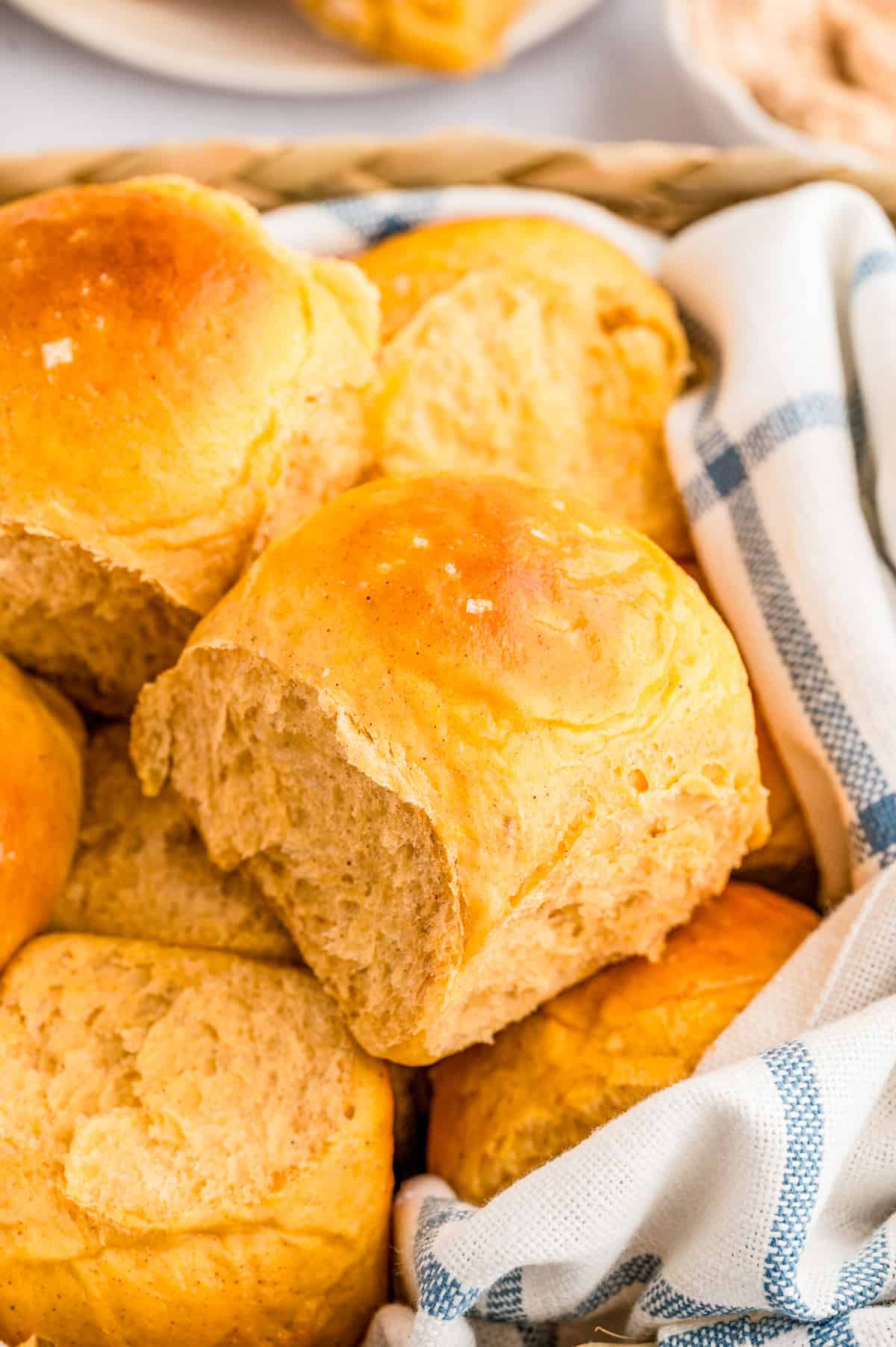 Sweet Potato Dinner Rolls in basket with white and blue linen.