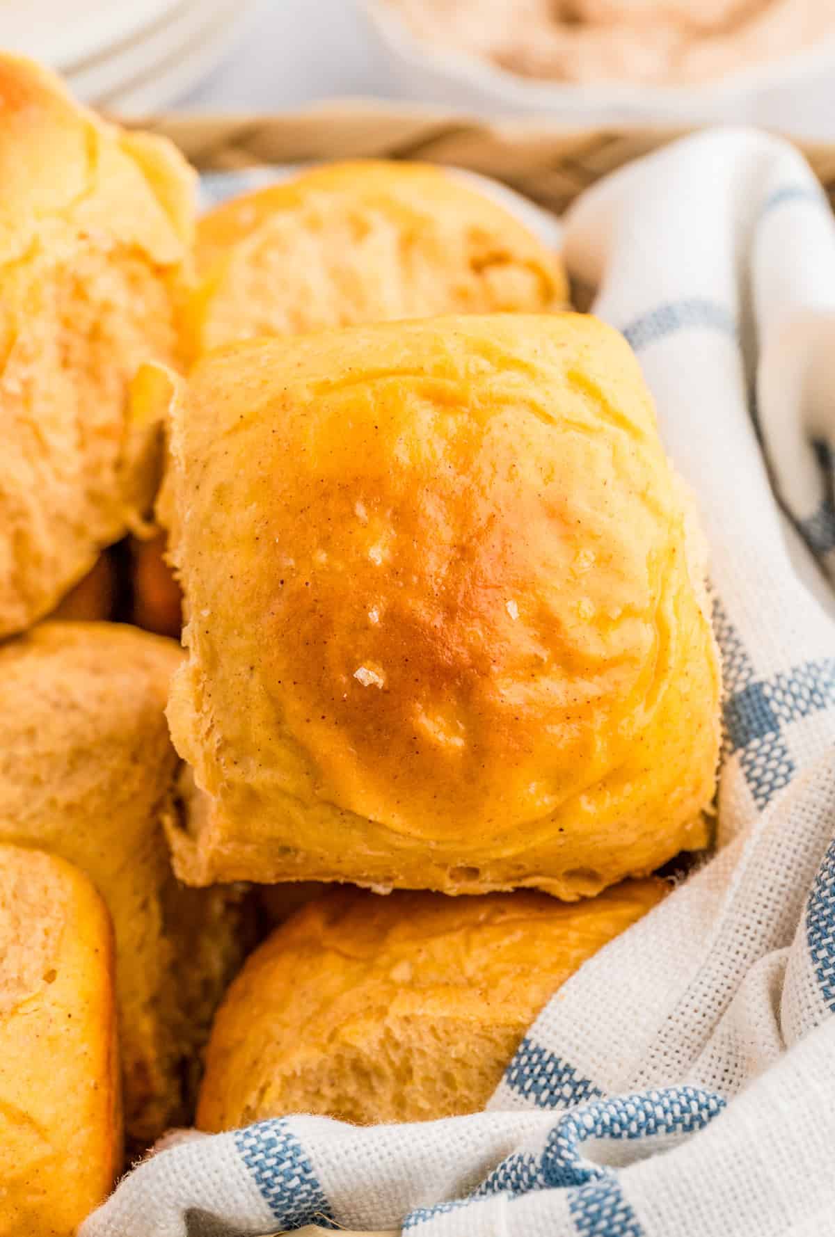 Close up of one Sweet Potato Roll in basket with other rolls.