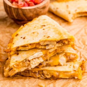 Close up square image of stacked quesadilla triangles.