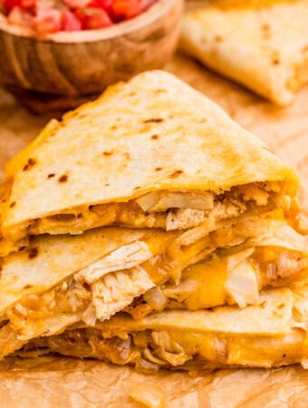 Close up square image of stacked quesadilla triangles.