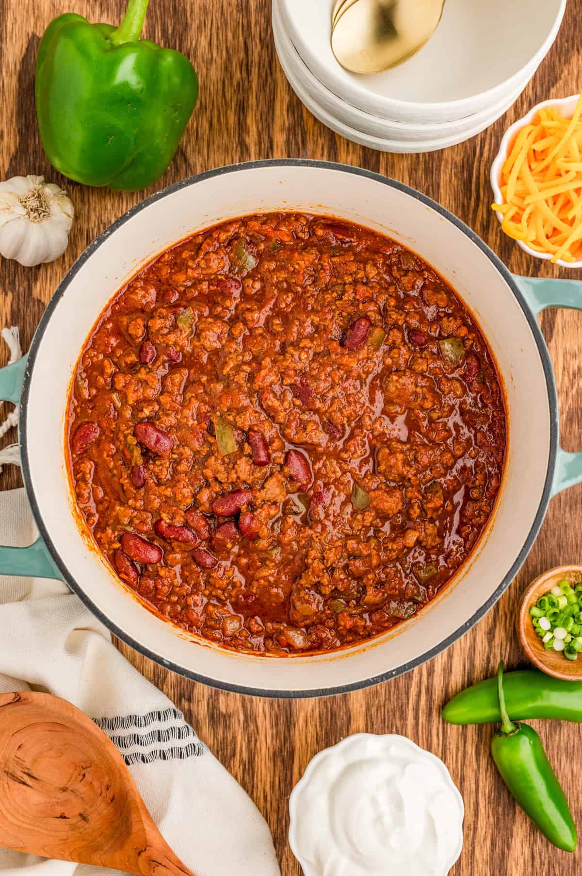 Finished chili in dutch oven with other ingredients surrounding pot.