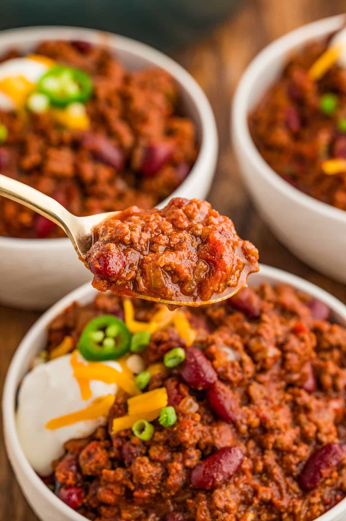 Spoon holding up some of the chili from the bowl.