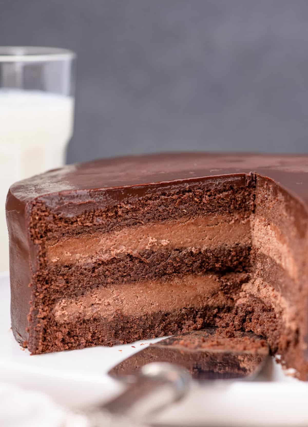 Slice of cake removed showing the inside of the cake with milk in background.