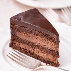 Slice of cake on white plate with fork.