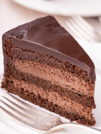 Slice of cake on white plate with fork.