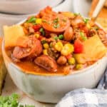 Close up square image of stew in bowl with spoon.