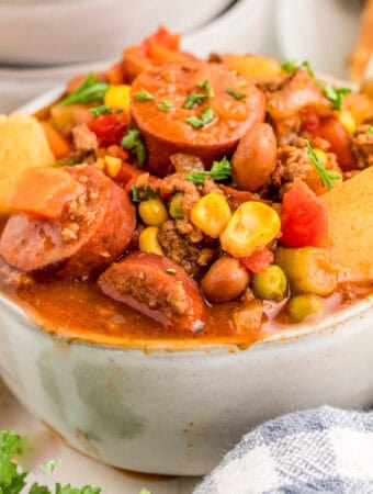 Close up square image of stew in bowl with spoon.