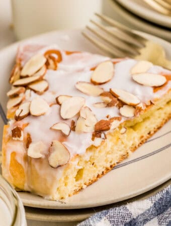 Square image of a slice of kringle on white plate showing the toppings.