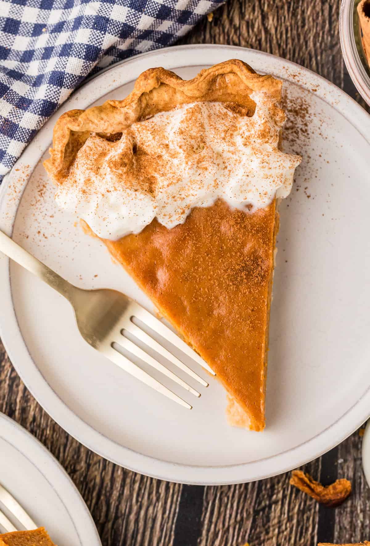 Slice of the Easy Pumpkin Pie on white plate with fork garnished.