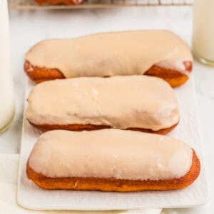 Square image of three donuts on white tray.