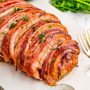 Close up square image of sliced meatloaf on white board.