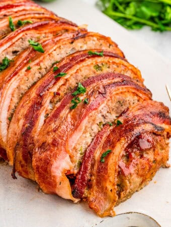 Close up square image of sliced meatloaf on white board.