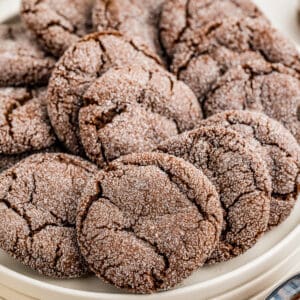 Close up of cookies layered on a white plate.