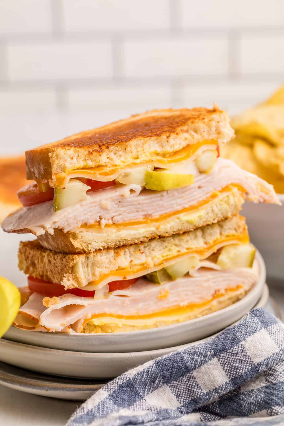 Turkey Melt sliced in half stacked on plate showing the layers of ingredients.