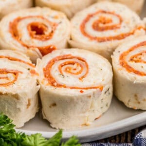 Close up square image of pinwheels on white plate.