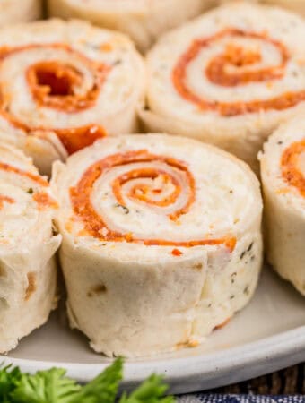 Close up square image of pinwheels on white plate.