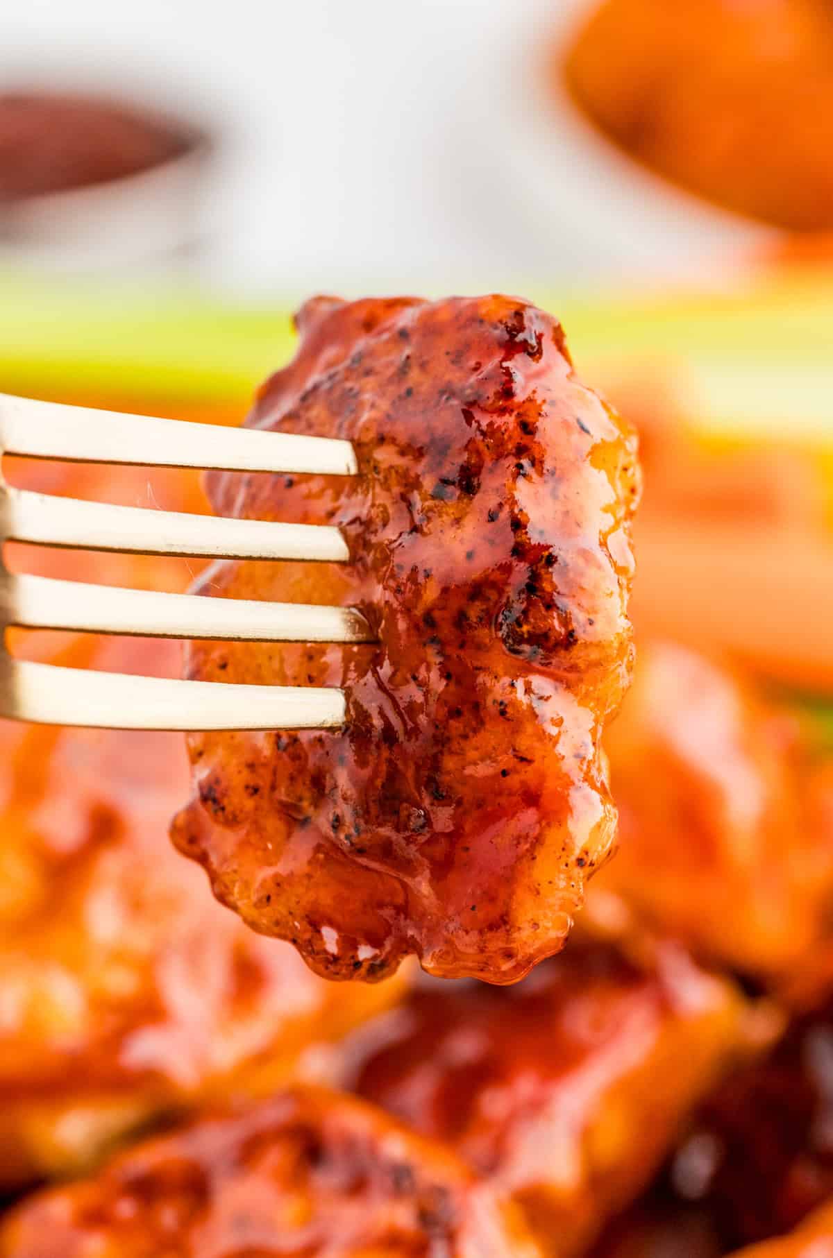 Fork holding up one piece of chicken.