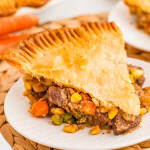 Square image of a slice of the pot pie on white plate.