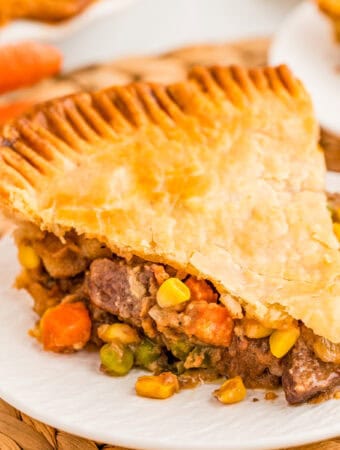 Square image of a slice of the pot pie on white plate.