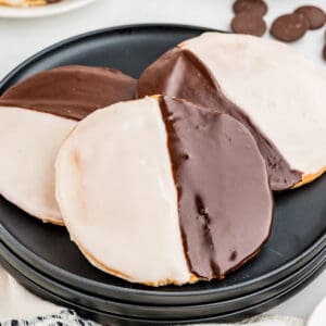 Square image of three cookies layered on black plate.