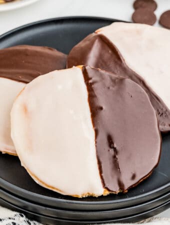 Square image of three cookies layered on black plate.