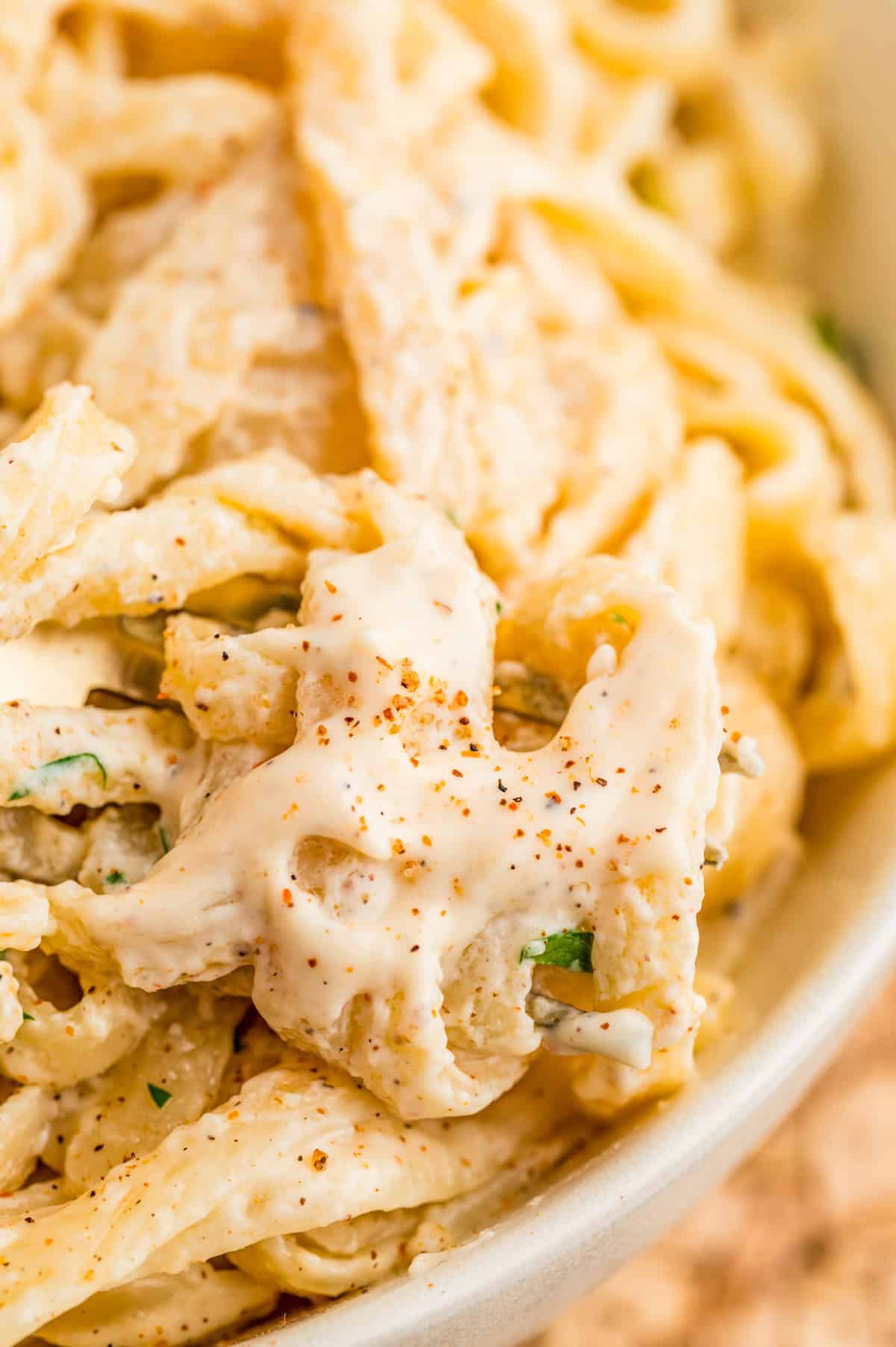 Close up of sauce over pasta topped with parsley.