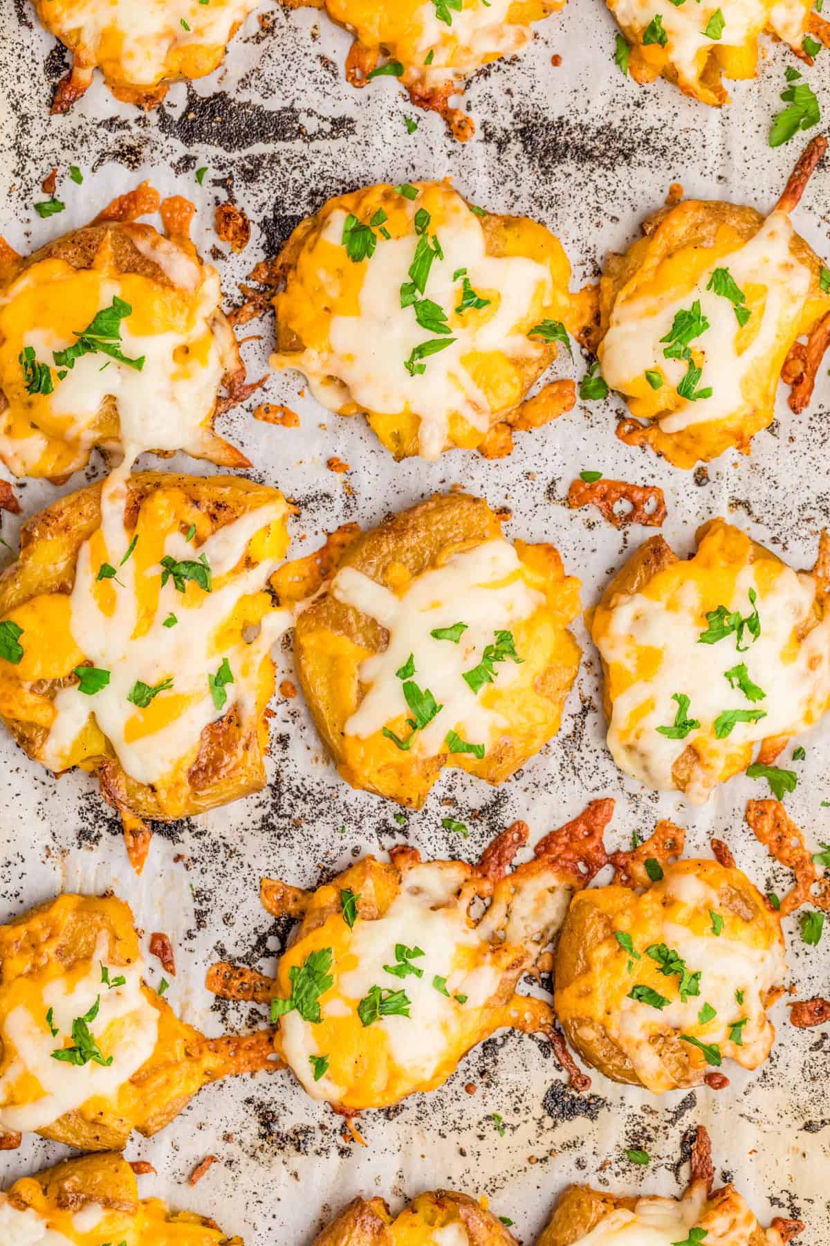 Finished Cheesy Smashed Potatoes on baking sheet topped with parsley.