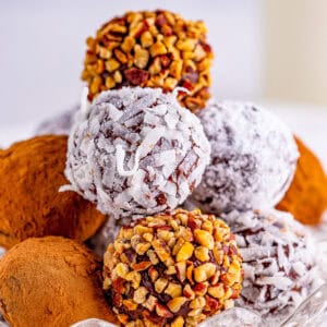 Close up square image of truffles stacked with multiple different coatings.