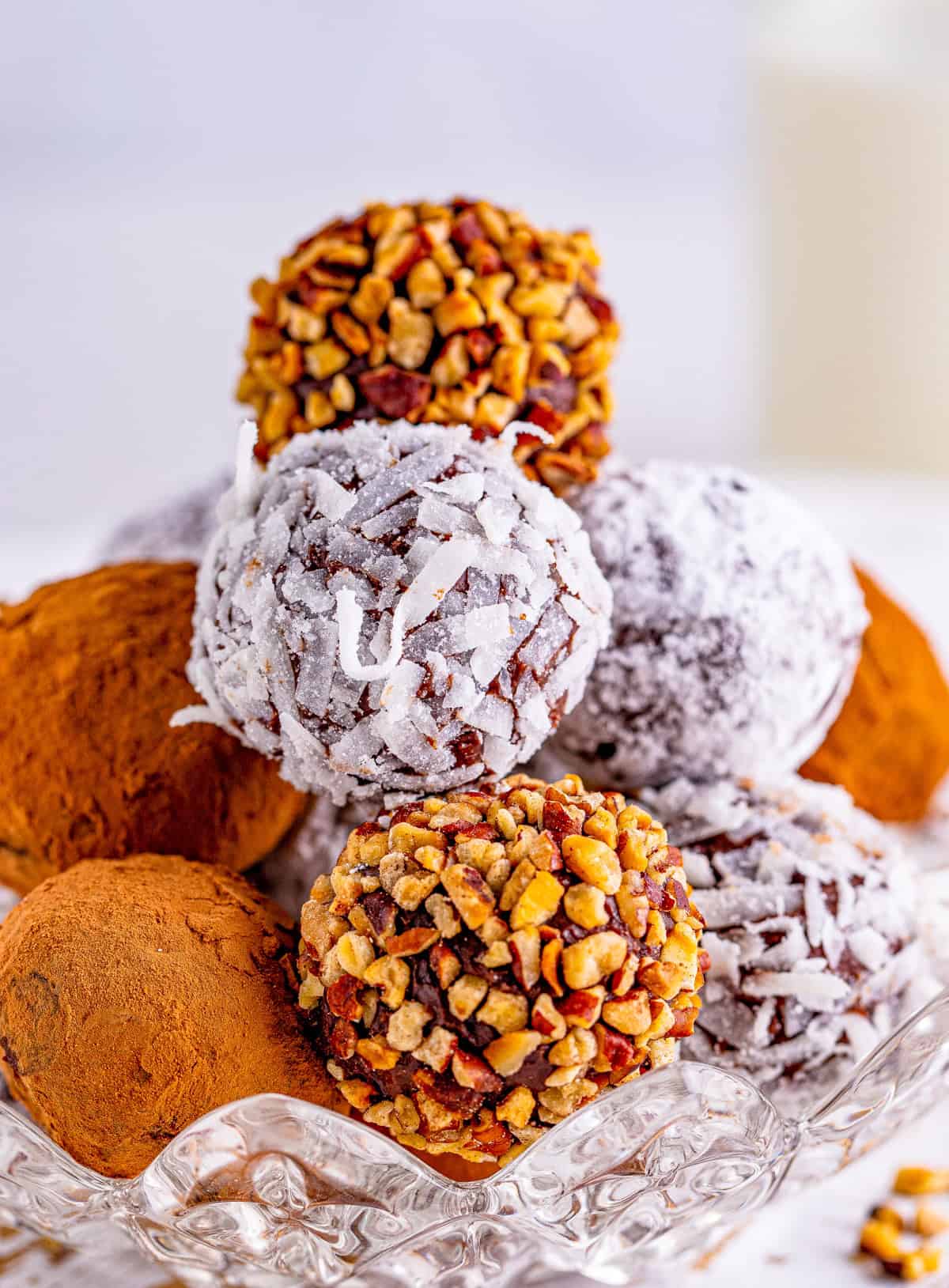 Easy Chocolate Truffles stacked in glass dish with multiple different coatings.