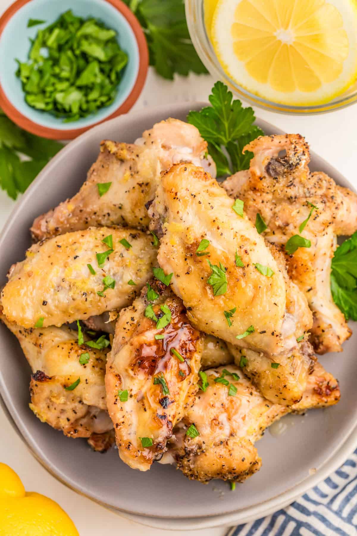 Overhead of wings on grey plate topped with parsley.