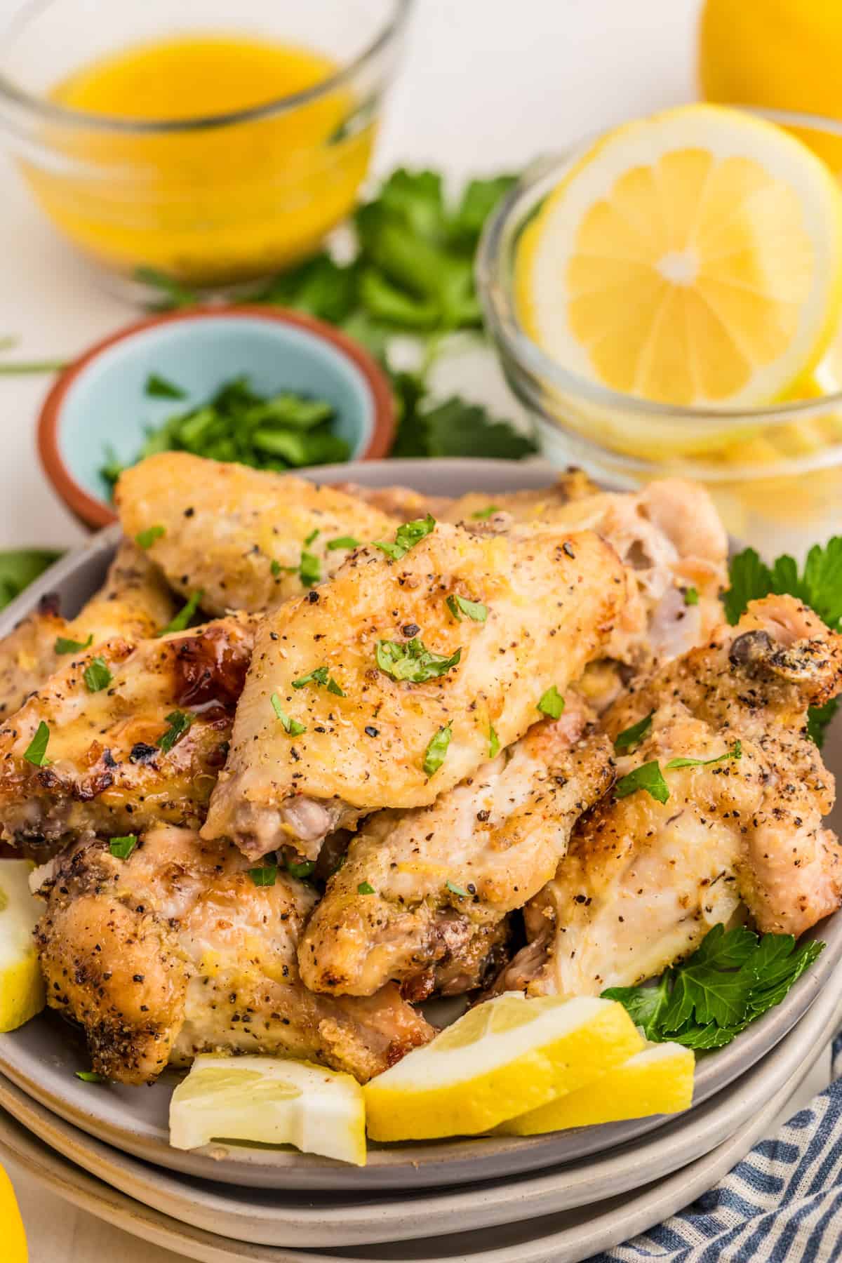 Lemon Pepper Wings on plate topped with parsley with lemon wedges.