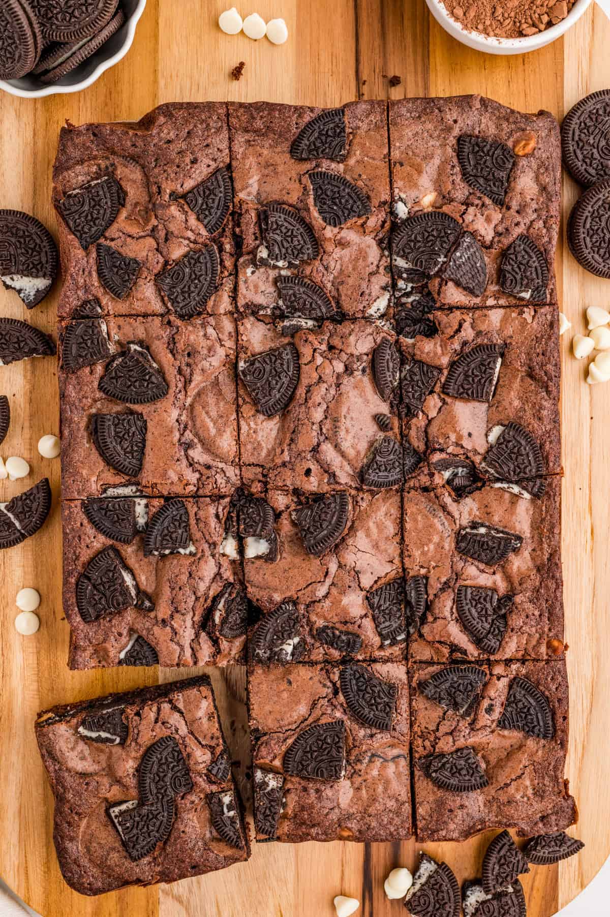 Overhead of cut brownies on wooden cutting board.