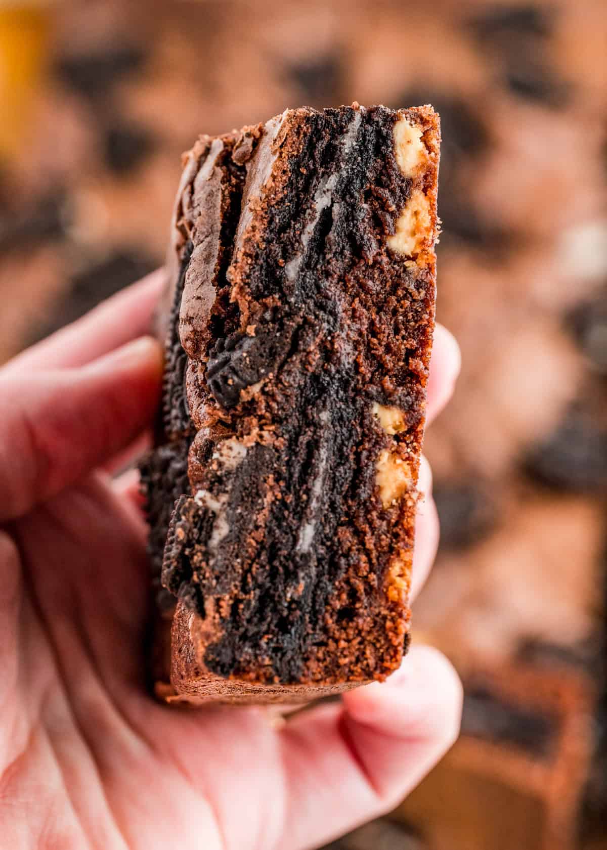 Hand holding up one of the Oreo Brownies showing the oreos inside.