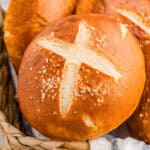Close up of one of the rolls in bread basket showing the cut and salt on top.