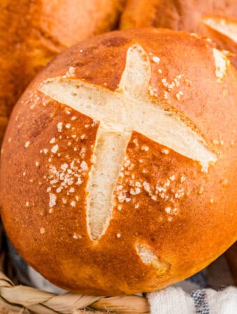 Close up of one of the rolls in bread basket showing the cut and salt on top.