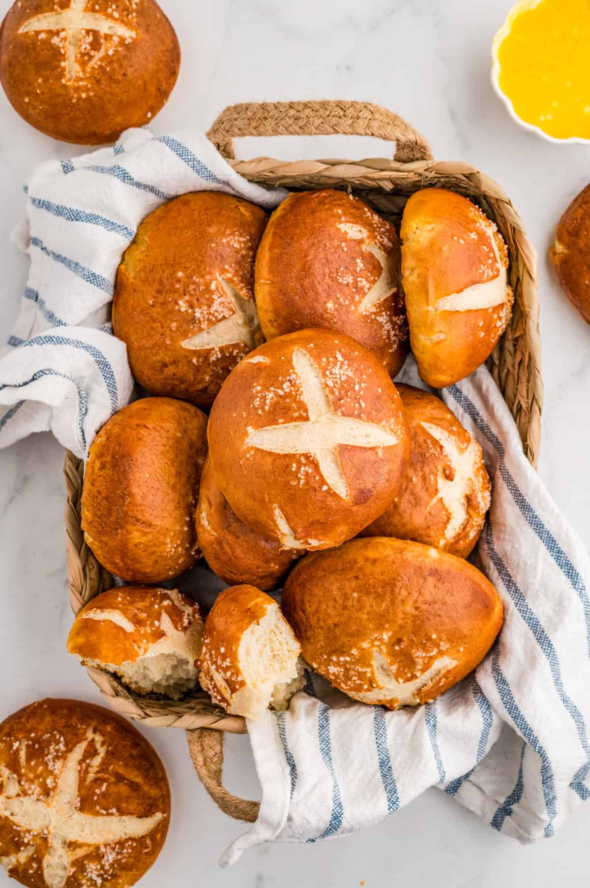 Overhead of Rolls in bread basket with striped linen.