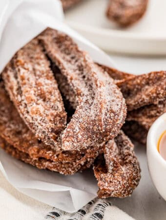 Close up of churros wrapped in parchment paper.