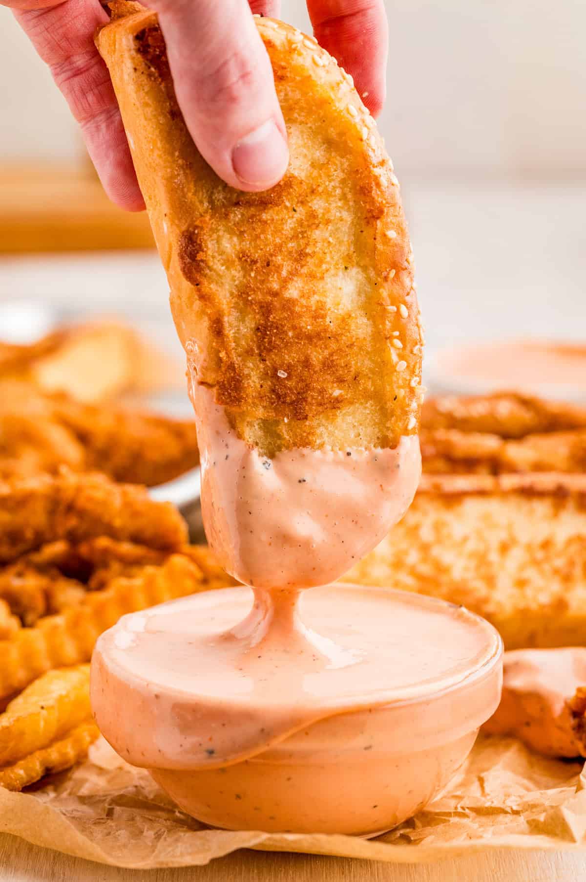 One slice of bread being dipped into sauce.