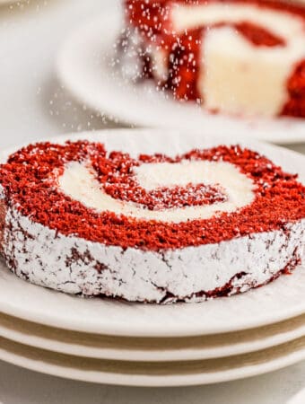 Square image of a slice of the cake on stacked white plates.