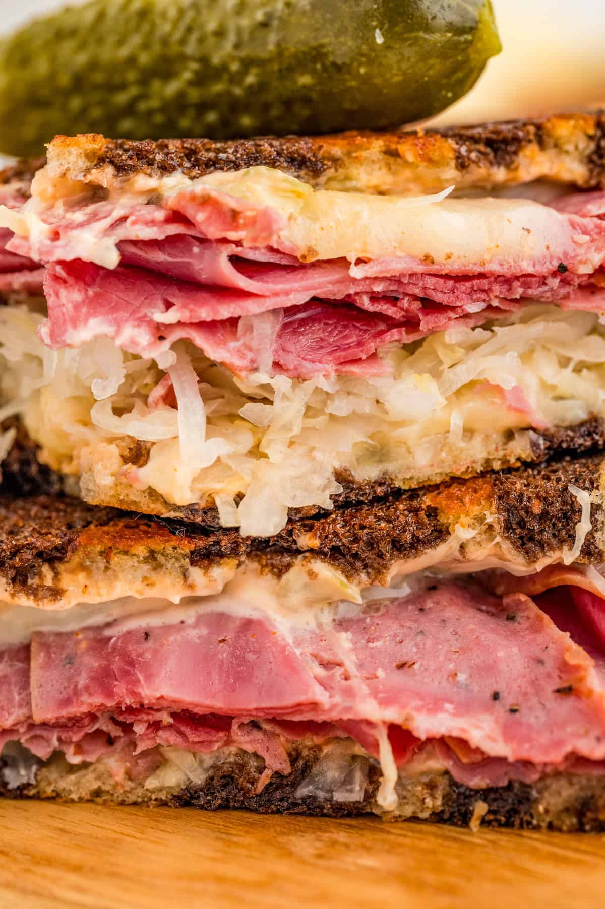 Close up of sandwich showing the layers of meat, cheese and sauerkraut.