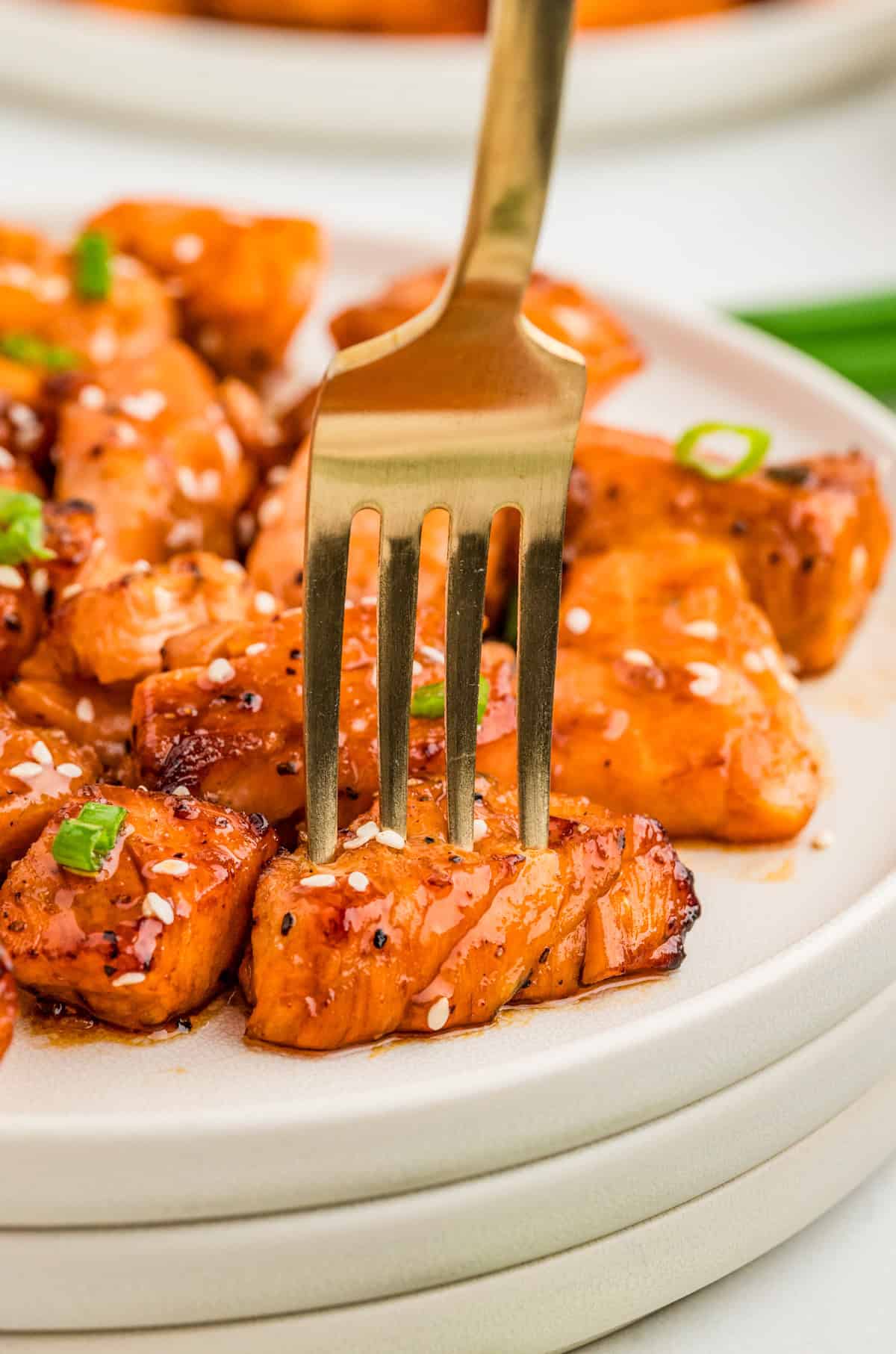 Fork going into one of the Air Fryer Salmon Bites on plate.