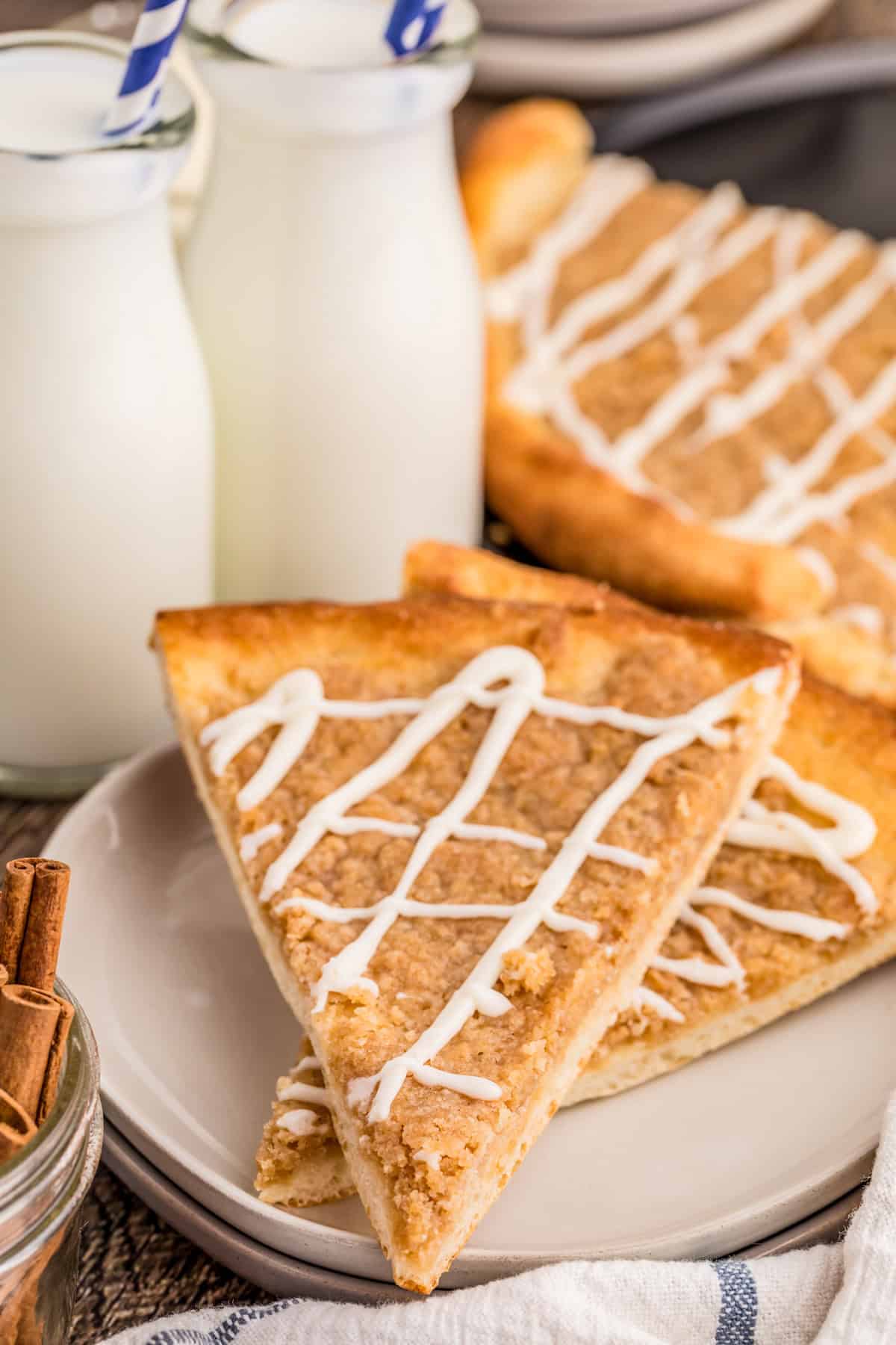 Finished Cinnamon Sugar Dessert Pizza stacked on top of one another with glaze.