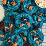 Square image of cookies stacked on top of one another on wire rack.