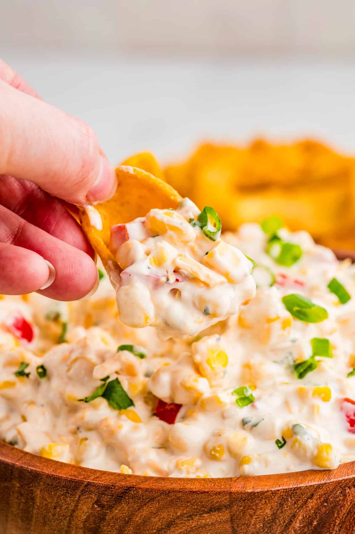 Hand holding a chip holding up some of the Corn Dip.