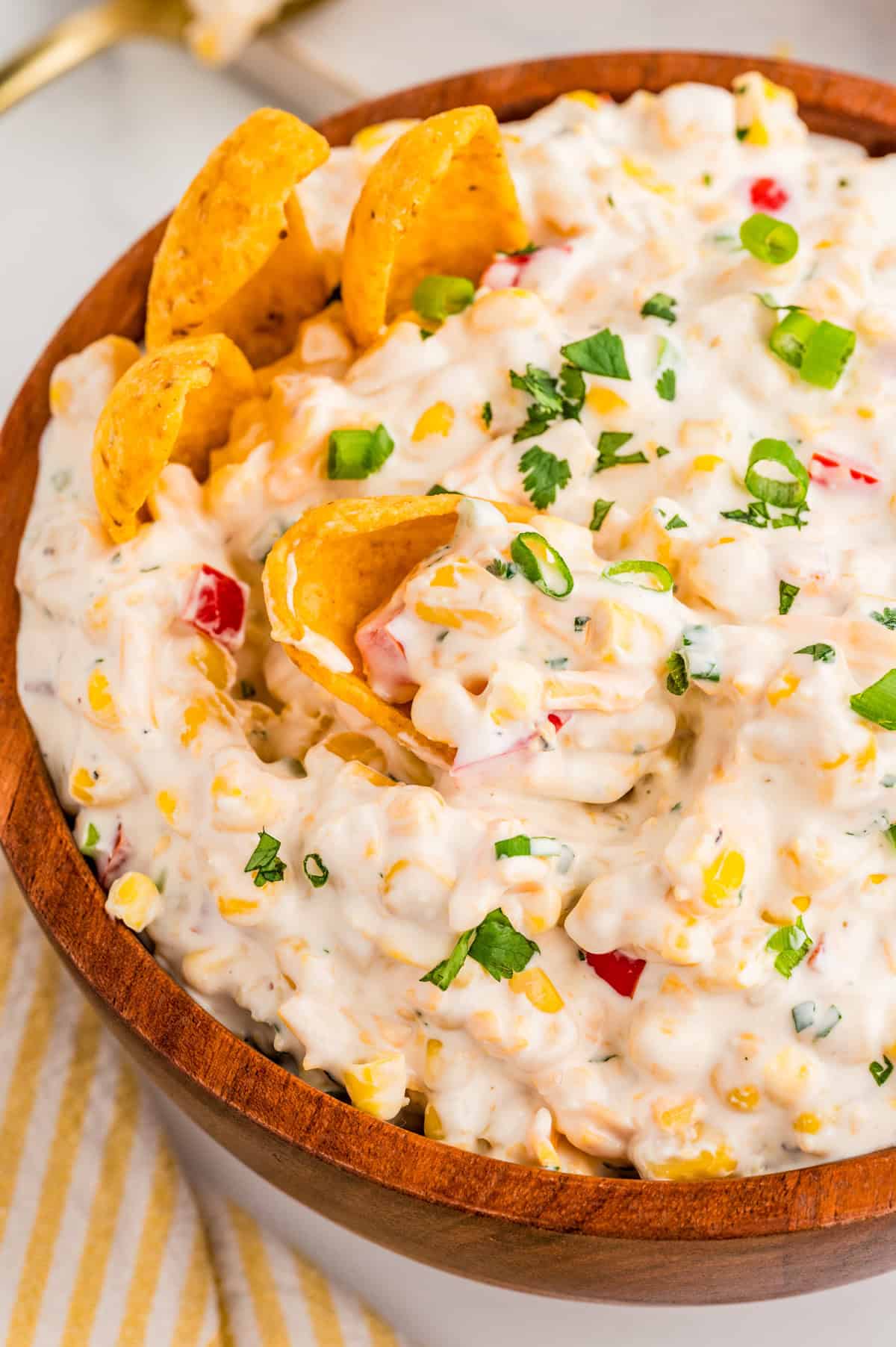 Overhead of dip in bowl topped with green onions and chips in bowl.