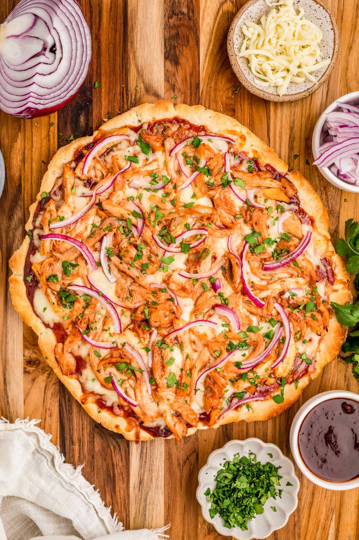 Overhead photo of finished BBQ Chicken Pizza uncut on wooden board.