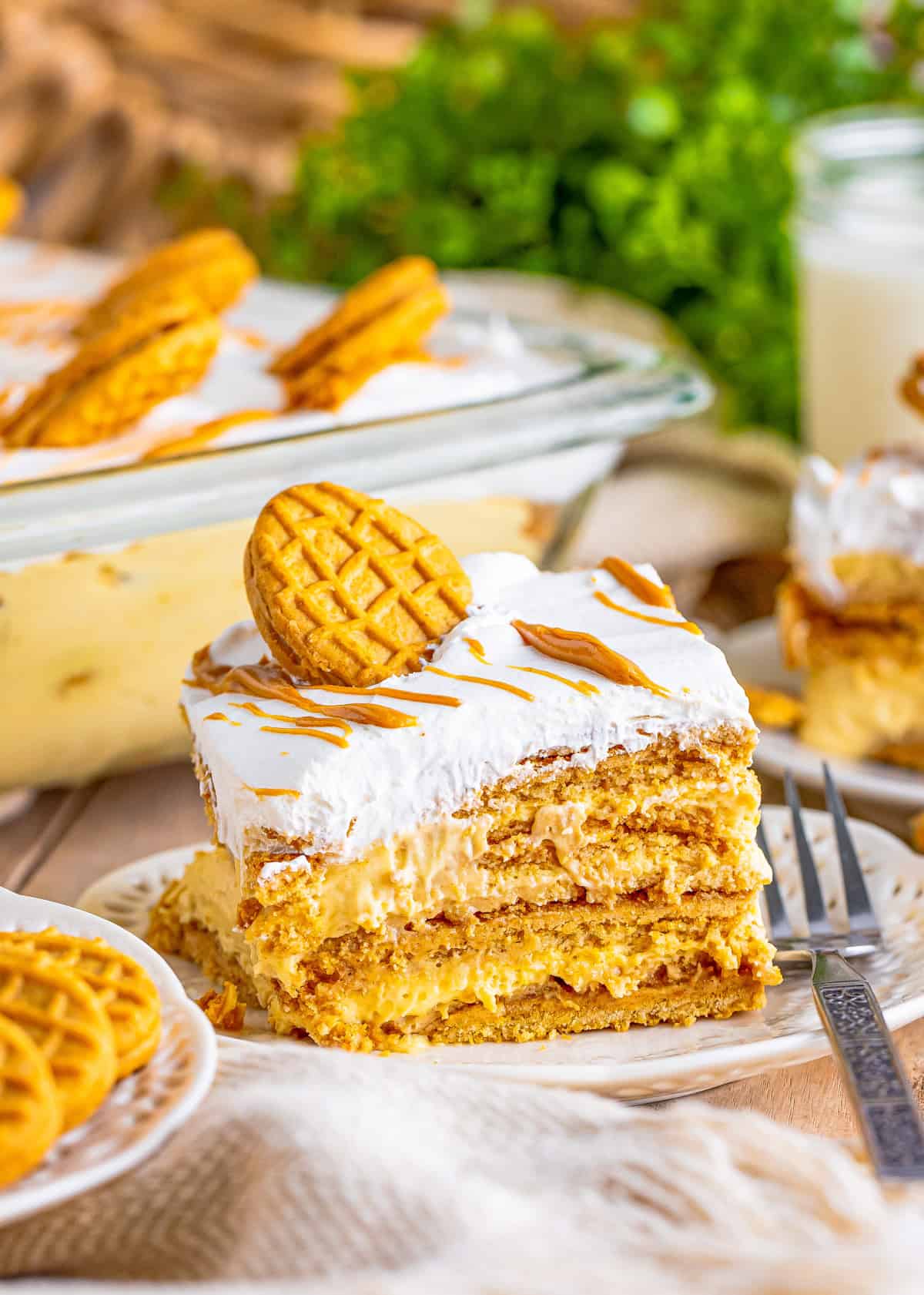 Slice of the Peanut Butter Icebox Cake on white plate topped with a nutter butter and fork next to slice.